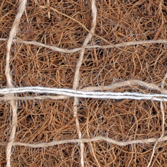 Dense coconut erosion control blanket held together with degradable string.