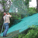 Using sprayer to apply hydromulch to slope.