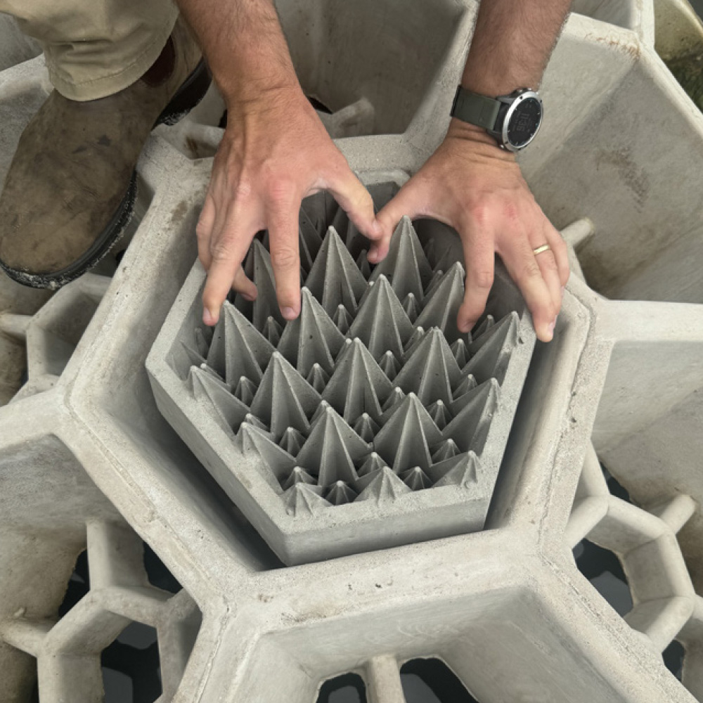 Hands placing Seawall Tiles into Reef Arches.