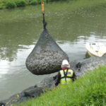 Installing Kyowa filter units along water bank.