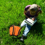 Person sitting in luscious and long-lasting perennial grass covering pastureland.