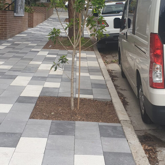 Urban tree soil cells supporting sidewalk pavers and promoting tree root growth.