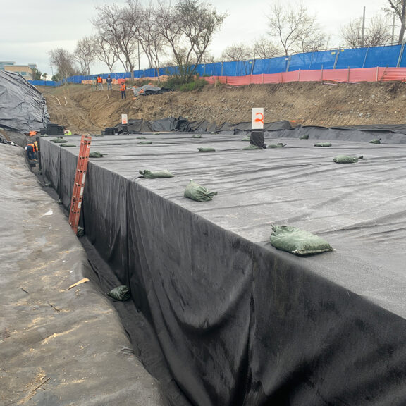 Installing subsurface drainage for slopes around existing utilities.