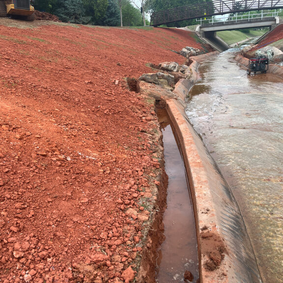 Installing hard armor along channel for stabilization.