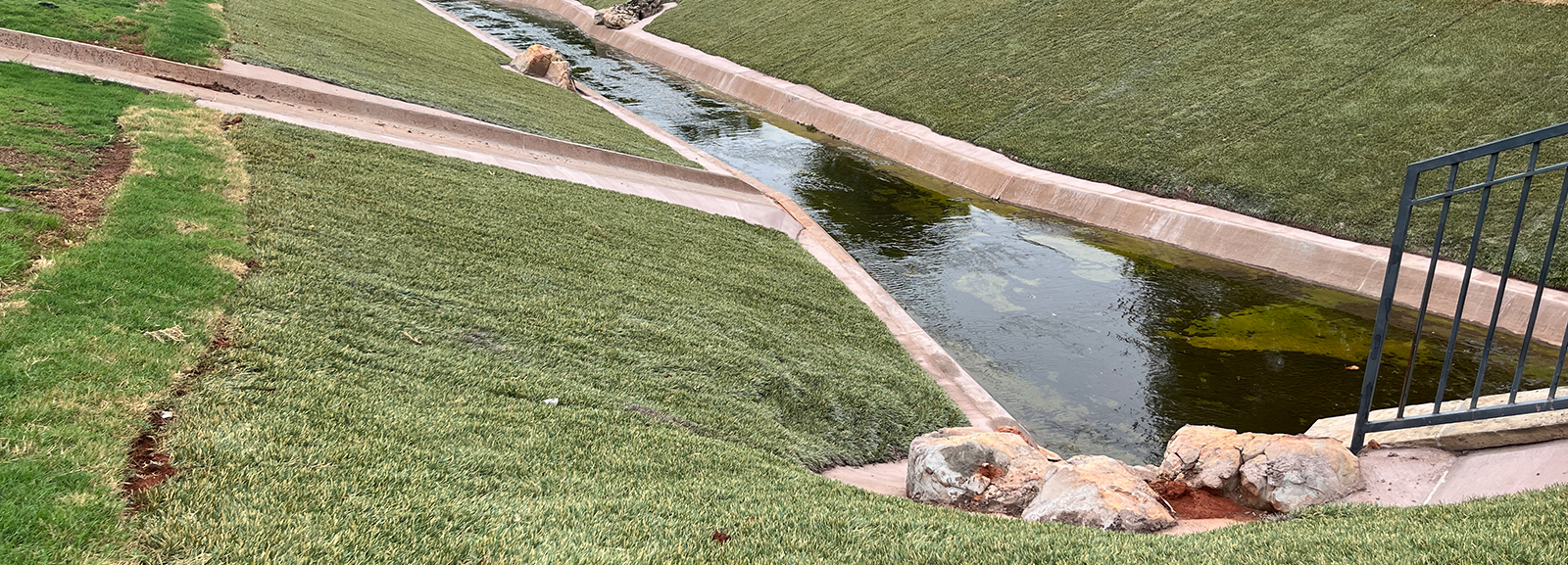 Hydroturf vegetated with grass on channel slopes for stabilization.