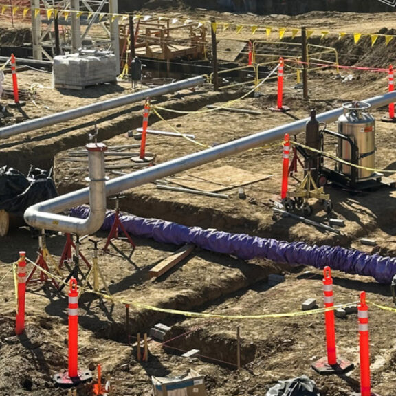Installing large steel pipes for an underground utility system according to precise design plans..