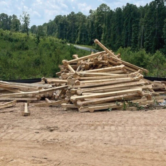 A pile of wood in a cleared area.