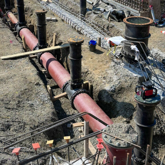 Installing red water treatment plant pipe underground.