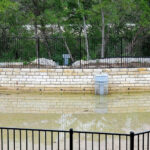 Inlet riser screen in shallow water retention area.