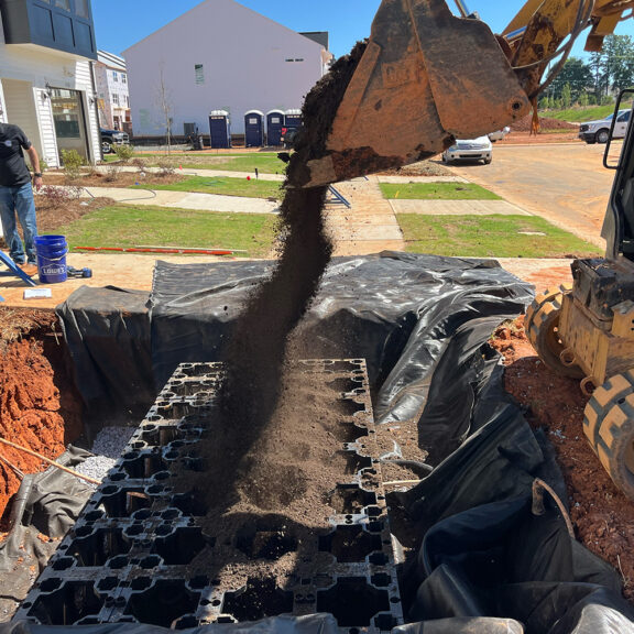 Backfilling soil cells in new housing development.