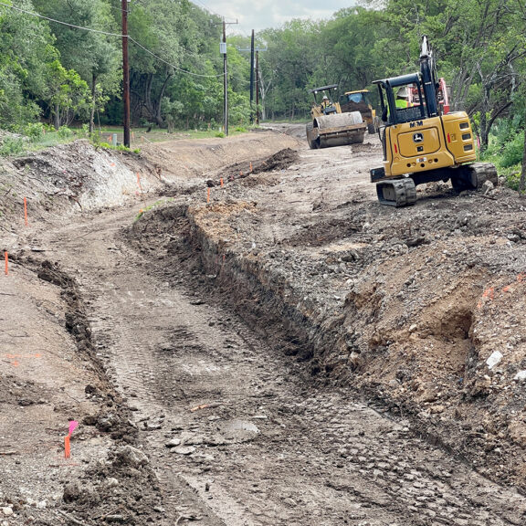Mini excavator clearing drainage channel